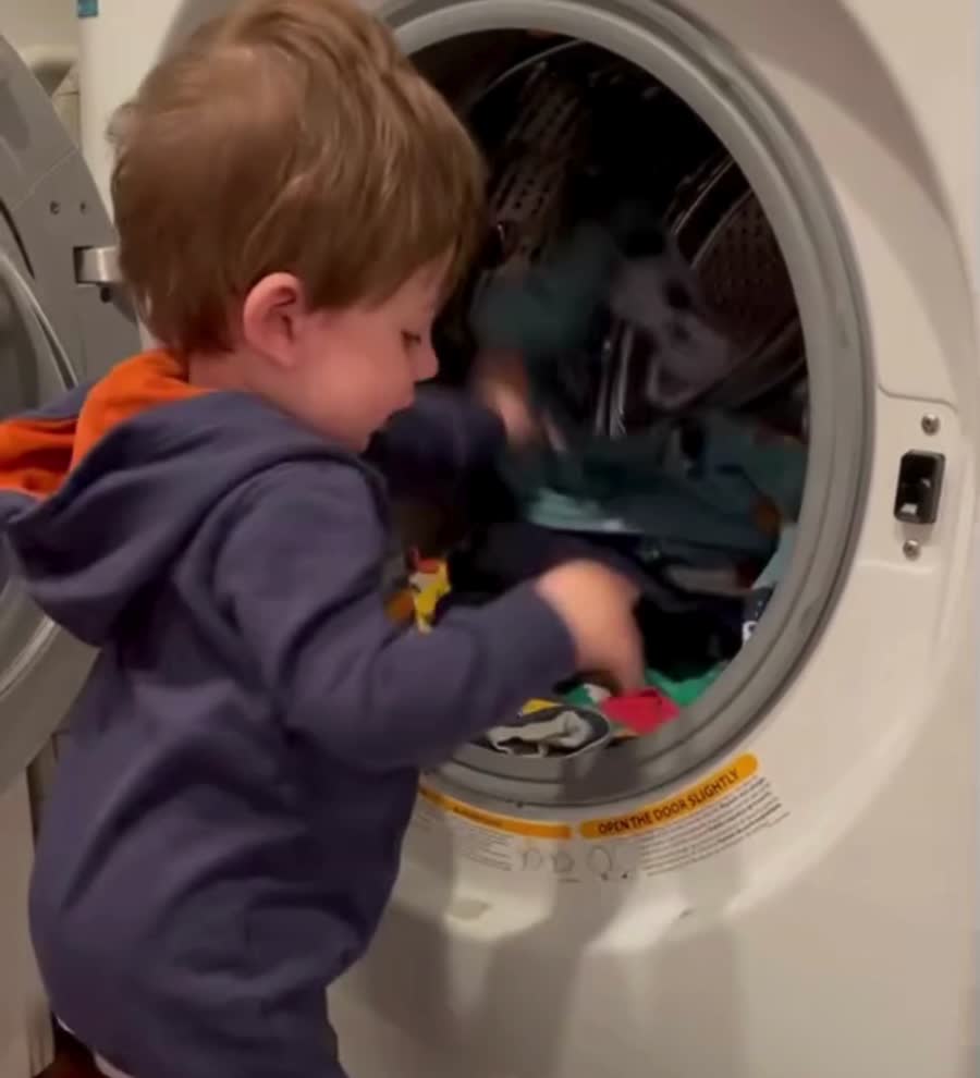 Michael’s nephew helping put laundry into the washing machine