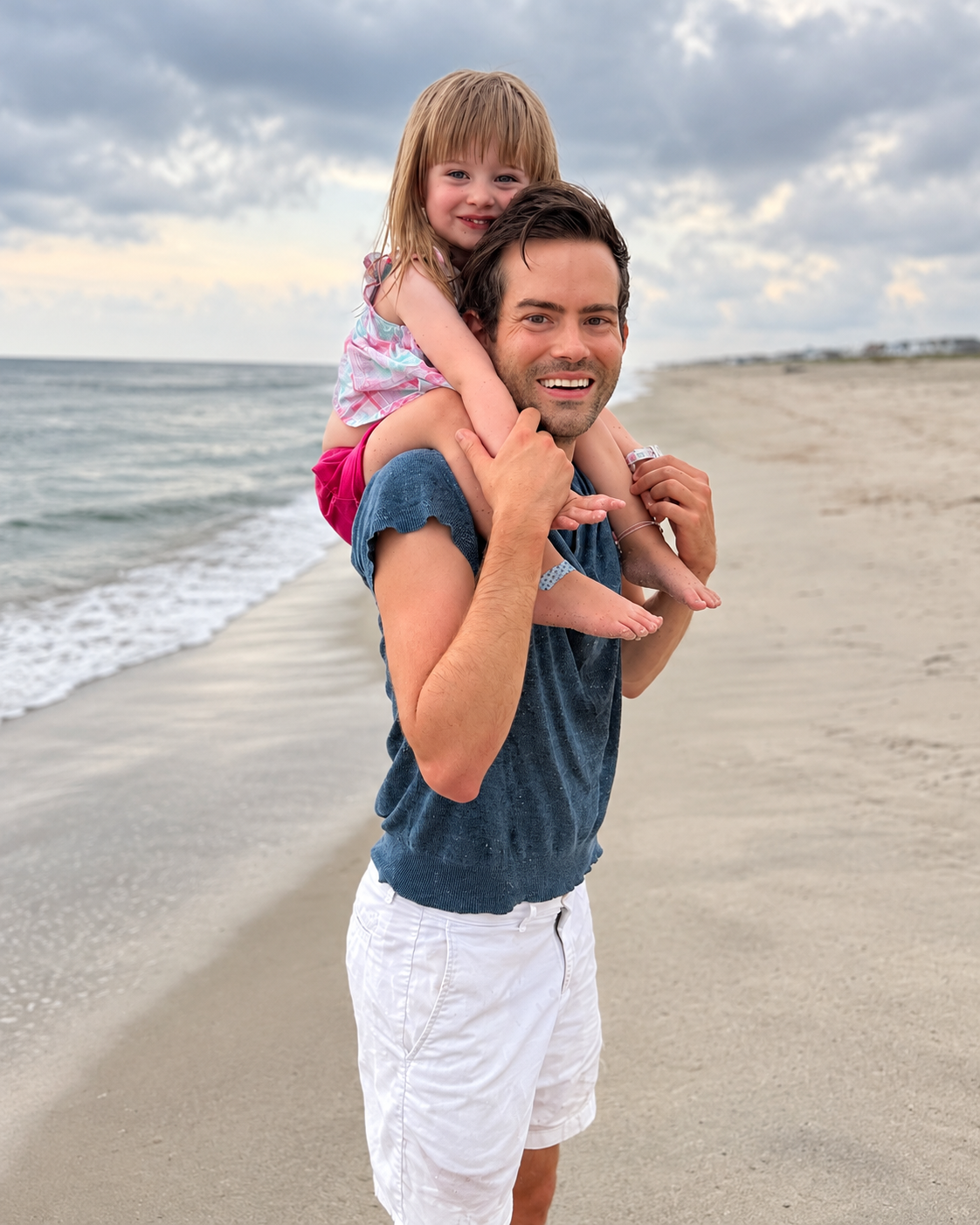 Michael carrying his niece on his shoulders at the beach